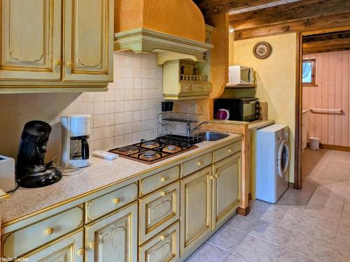 une cuisine avec une cuisinière et un réfrigérateur dans l'établissement Charmante maison en pierre au cœur des Vosges - FR-1-583-436, à Saint-Bresson