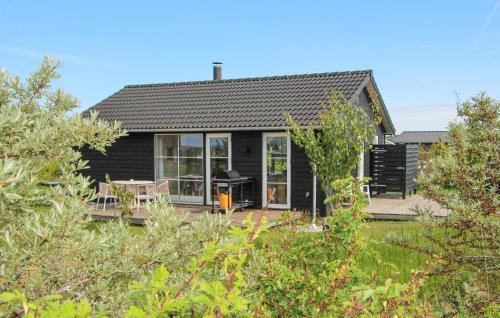 a black house with a deck and a grill at 3 Bedroom Cozy Home In Lundby in Lundby