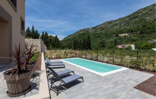 ein Swimmingpool mit drei Liegestühlen neben einem Haus in der Unterkunft 2 Bedroom Beautiful Home In Kremena in Kremena