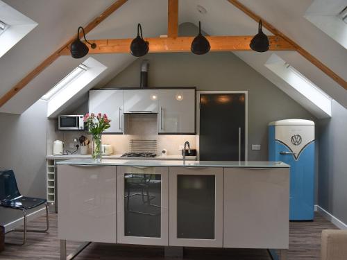 a kitchen with a white island in a attic at Priory Barn in Freshwater