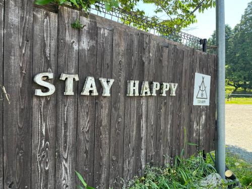 a fence with the words stay happy written on it at 南阿蘇 StayHappy in Minami Aso
