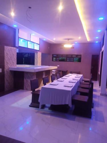 a dining room with a long table and some chairs at ASVA BEACH Resort in Grand-Popo