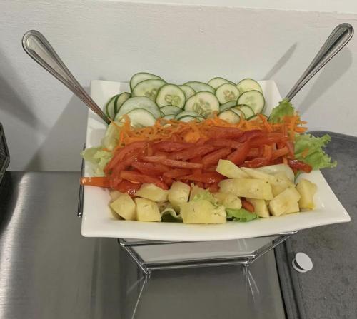a plate of food with carrots potatoes and cucumbers at Sommerville Resorts in Negril