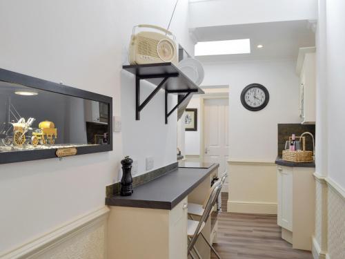 a kitchen with a counter and a clock on the wall at The Little House in York