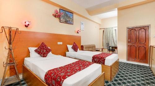 a hotel room with two beds and a desk at Hotel Gangotri Pvt Ltd in Bharatpur