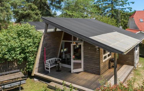 a small house with a black roof on a deck at 1 Bedroom Cozy Home In Væggerløse in Bøtø By