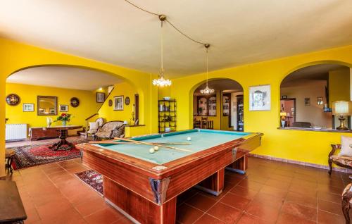 a pool table in a room with yellow walls at Il Piazzone in Monte San Savino