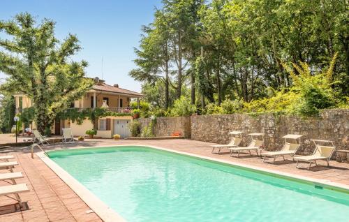 a swimming pool with patio furniture and a stone wall at Il Piazzone in Monte San Savino