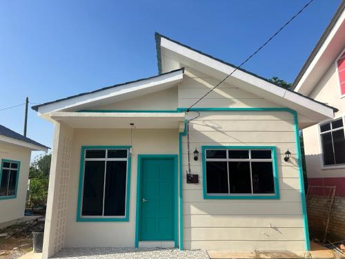 a small white house with a green door at Homestay Pendang Murah in Pendang