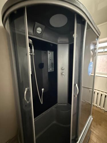 a shower with a glass door in a room at Mukarama in Bishkek
