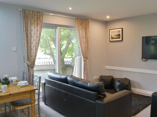 a living room with a couch and a table at Puffin - Kerrera in Lerags