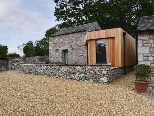 a stone house with a window and a stone wall at The Bothy in Beetham