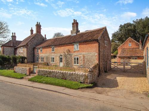 an old brick house with a fence in front of it at Cherry Tree Cottage - Uk30237 in Great Snoring