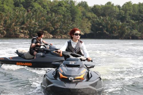 two people riding on a jet ski in the water at Wonderland Suites and Resort in Sihanoukville