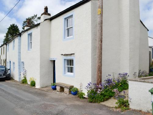 a white house with flowers on the street at Springlea Cottage in Dean