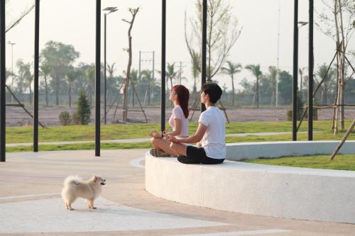 a group of three people sitting on a bench with a dog at Wonderland Suites and Resort in Sihanoukville