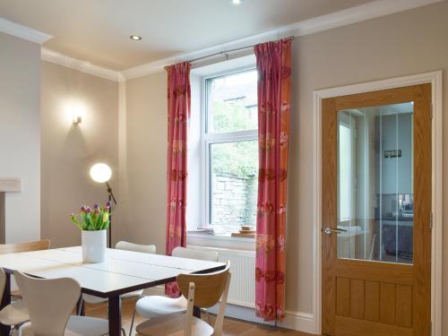 a dining room with a table and chairs and a window at Ash Grove in Skipton
