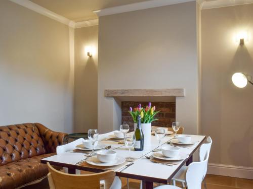 a dining room with a table and a couch at Ash Grove in Skipton