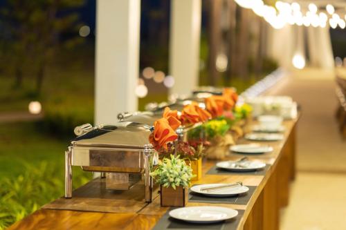 a long table with plates and flowers on it at Wonderland Suites and Resort in Sihanoukville