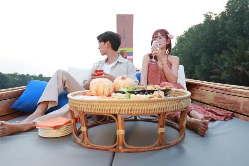 a man and woman sitting on a boat with a table of food at Wonderland Suites and Resort in Sihanoukville