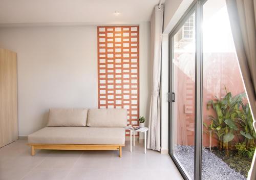 a living room with a couch and a window at ORA Serviced Apartments - Binh Duong New City in Thu Dau Mot