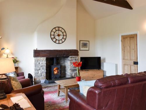 a living room with a couch and a fireplace at High Dalton Hall Cottage in Newsham