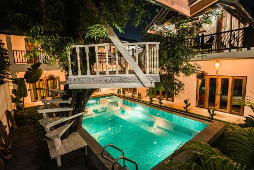 uma vista superior de uma piscina com um deque sobre ela em Garden Yard Inn Chiangmai em Chiang Mai
