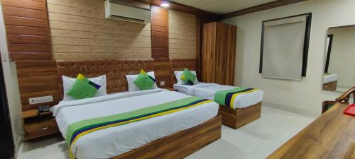 two beds in a room with wooden walls at Airport Hotel The Paramont Palace Inn New Delhi in Jāmb