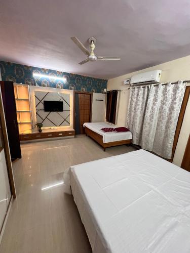 a bedroom with two beds and a ceiling fan at HomeStay by RAM Group of Hotels in Chhatikara