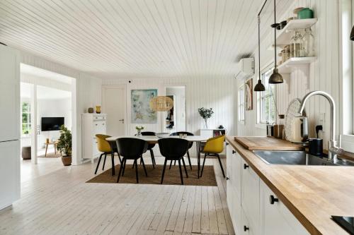 a kitchen with a table and yellow chairs in it at Bright And Classic House Near Høve Beach in Asnæs
