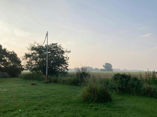 a field with a pole in the grass at Log House In Holbæk With Vintage Charm in Holbæk