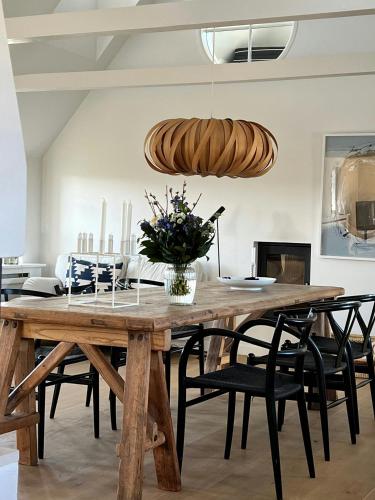a dining room with a wooden table and chairs at Aesthetic Rural Idyll In East Funen in Nyborg