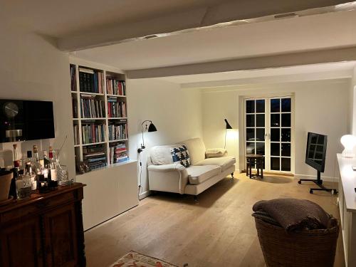 a living room with a white couch and book shelves at Aesthetic Rural Idyll In East Funen in Nyborg