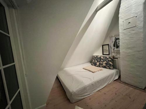 a small room with a bed in the attic at Aesthetic Rural Idyll In East Funen in Nyborg