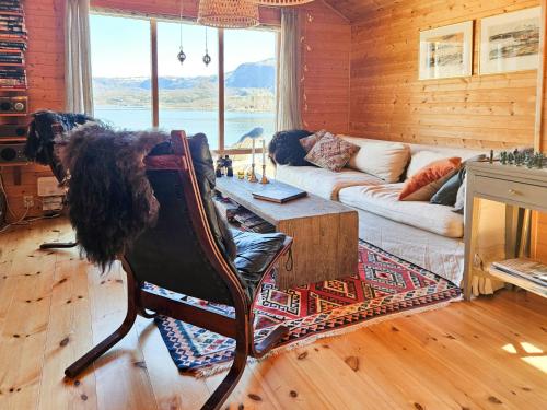 a living room with a dog sitting in a chair at Seaside Cabin With Panoramic Views In Oterstranda in Inndyr