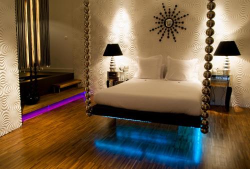 a bedroom with a swinging bed with a mirror at Abalú Small Luxury & Design Boutique Hotel in Madrid