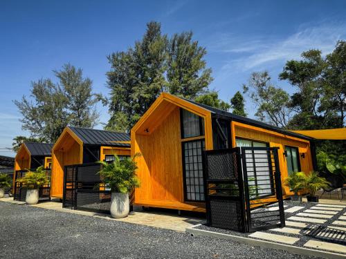 a row of orange modular homes at Sea Salt Casa Bang Tao in Ban Thalat Choeng Thale