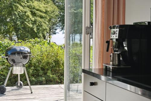 a kitchen with a window with a helmet on a tripod at Moderne Familiesommerhus Ved Hav Og Aktiviteter in Nysted