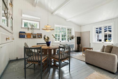 a dining room with a table and chairs at Cozy Summerhouse On Bornholm in Vester Sømarken