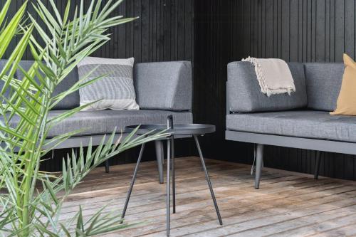 a living room with a chair and a couch at Moderne Familiesommerhus Ved Hav Og Aktiviteter in Nysted