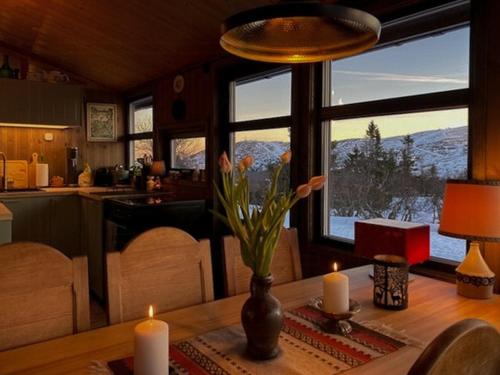 a table with candles and a vase with flowers on it at Original Trybo Cabin At Trysil Mountain in Trysil