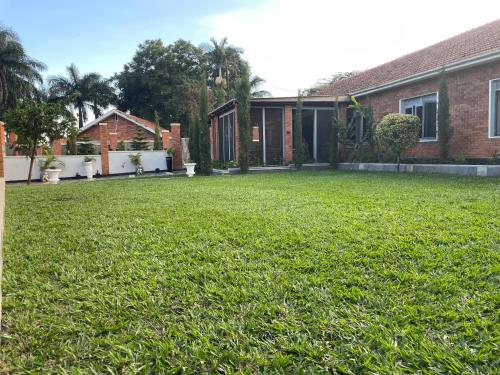 a yard of a house with a large lawn at A Modern 4Bedroom Furnished House In Rubaga For Rent in Kampala