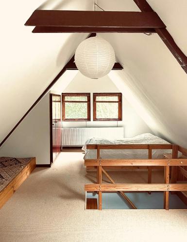 a attic room with two beds and a light fixture at Authentic 60S Gem In Rø Near Gudhjem in Gudhjem