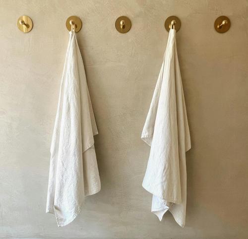 two white towels are hanging on a wall at Country Holiday Home Experience Design Nature in Skäret