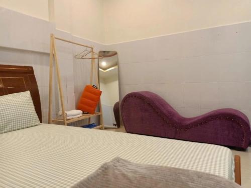 1 dormitorio con cama y silla morada en Ngân Anh Motel, en Rạch Giá