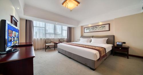 a hotel room with a bed and a flat screen tv at Sanyu Hotel in Guangzhou