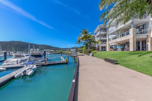 a marina with boats docked next to a building at Marina Living with views and more in Airlie Beach