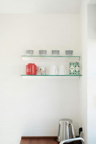 a kitchen shelf with cups and dishes on it at Enjoy Sea Views In This Skagen Beach Summer House in Skagen