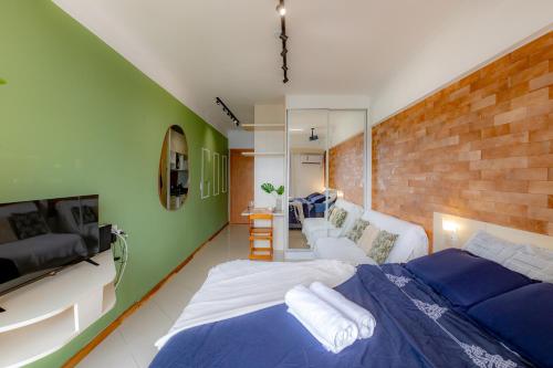 a bedroom with a bed and a brick wall at PROMOÇÃO - Vista Superior - Jacuzzi - Sauna - Piscina - Vaga Grátis 400m da Praia in Balneário Camboriú