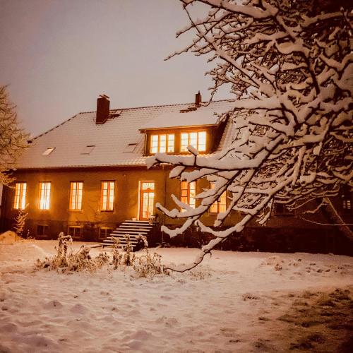 a house covered in snow at night at Rustic Holiday Apartment, Lovingly Restored in Rambin